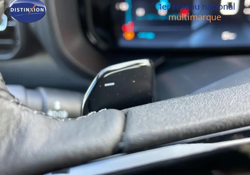Gros plan sur la commande au volant en cuir noir du Citroën Berlingo Multispace 2025, intérieur moderne avec écran tactile flou.