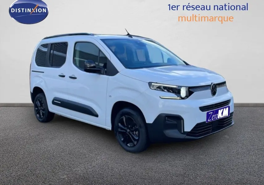 Vue 3/4 avant droit du Citroën Berlingo Multispace blanc glacier avec jantes noires et protections latérales noires.
