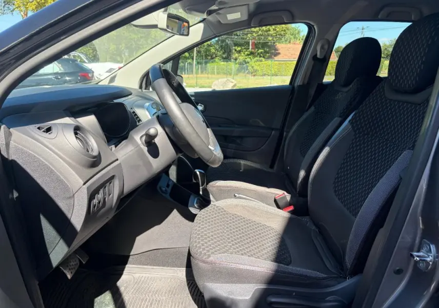 Vue intérieure côté conducteur du Renault Captur gris 2017, montrant sièges avant et tableau de bord.
