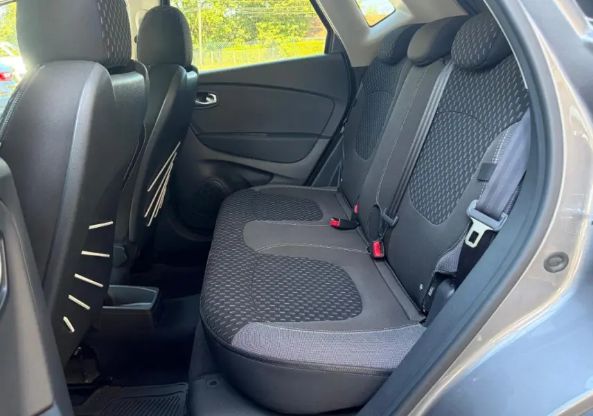 Vue intérieure côté droit des sièges arrière gris du Renault Captur 2017 avec banquette 1/3-2/3 et ceintures visibles.