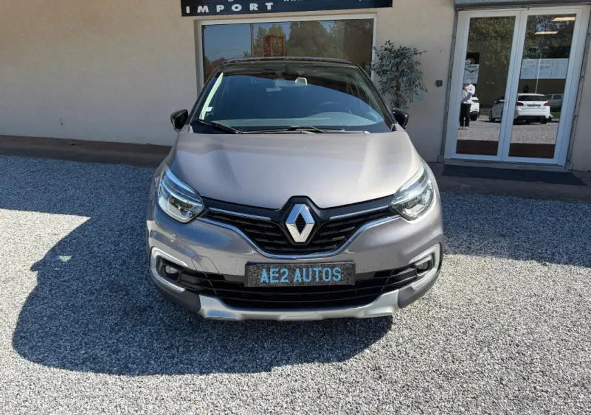 Vue avant d'un Renault Captur gris métallisé 2017 avec calandre noire et plaque AE2 AUTOS visible.