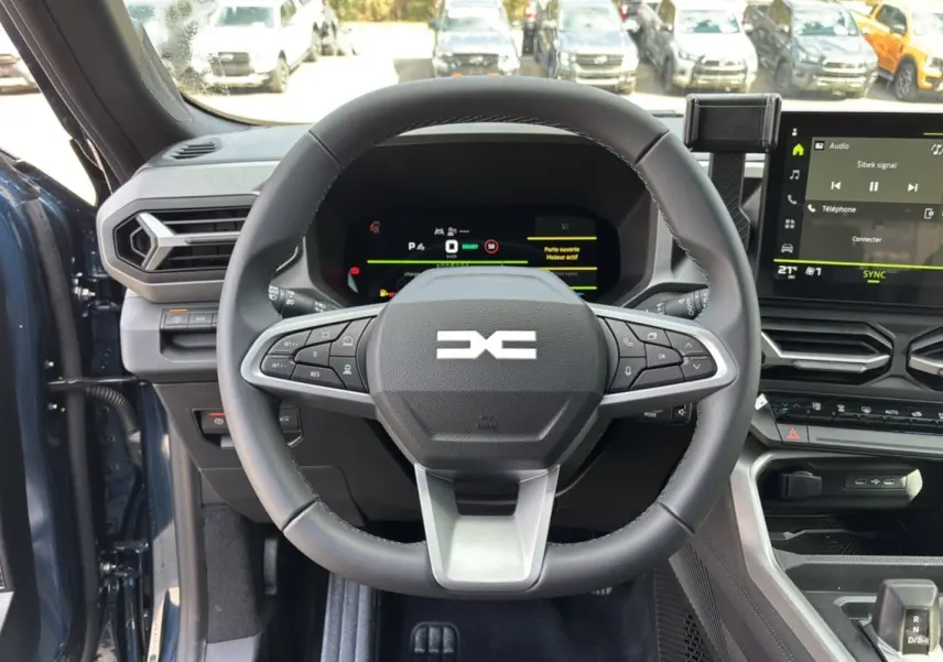Vue frontale du volant cuir et tableau de bord digital du Dacia Bigster Hybrid 155 en bleu indigo.