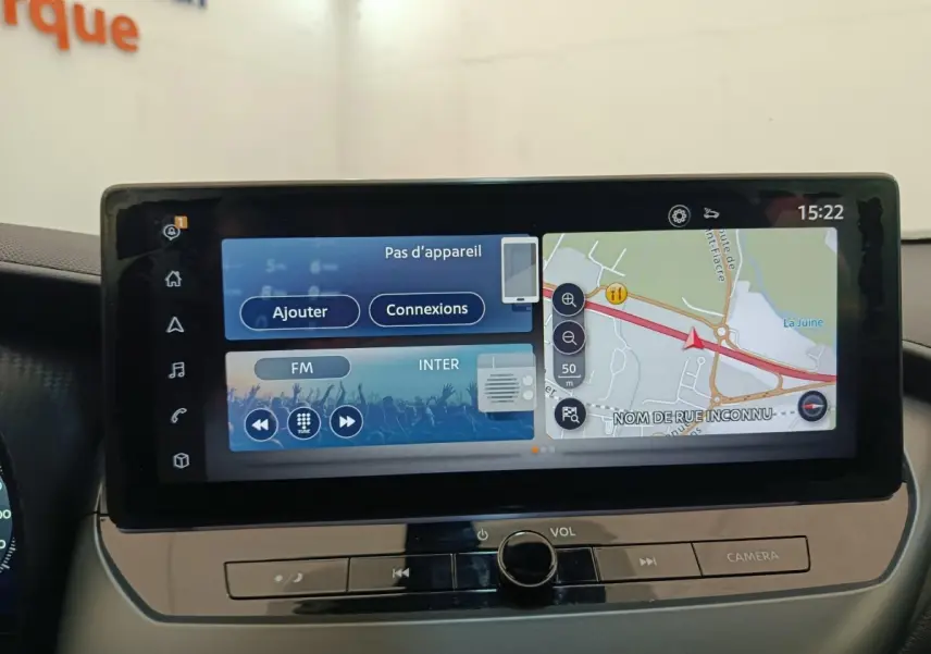 Écran tactile central du tableau de bord du Nissan Juke gris clair, affichant navigation et options multimédia.