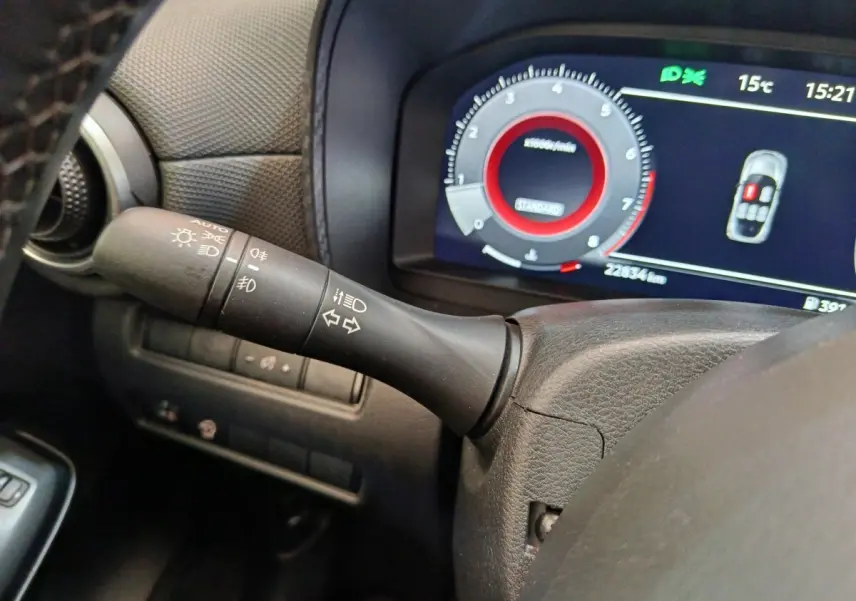 Gros plan sur la manette de clignotants et le combiné d'instruments numérique du Nissan Juke gris clair 2025.