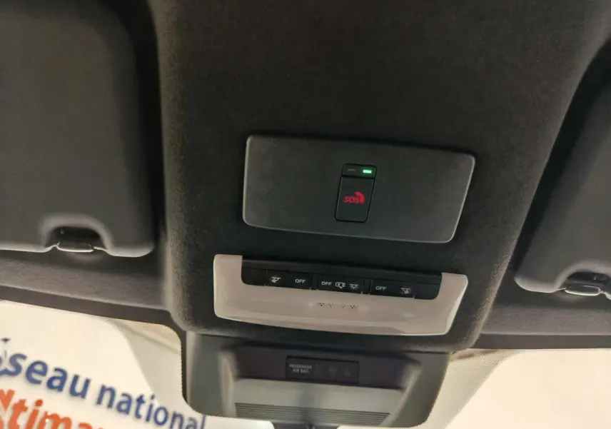 Vue intérieure du plafond du Nissan Juke 2025 avec bouton SOS rouge et commandes d'éclairage intégrées.