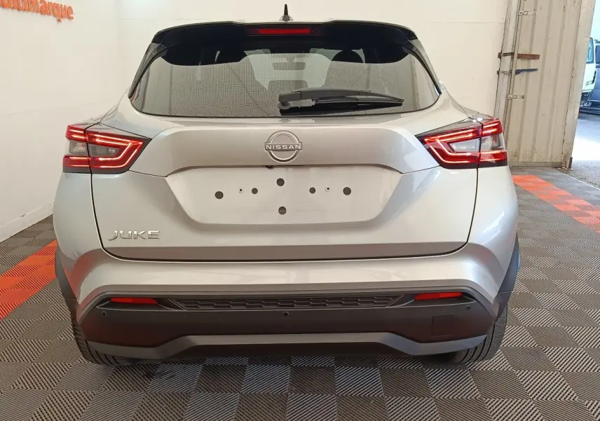 Vue arrière d'un Nissan Juke gris clair 2025 avec feux LED et logo Nissan bien visibles.