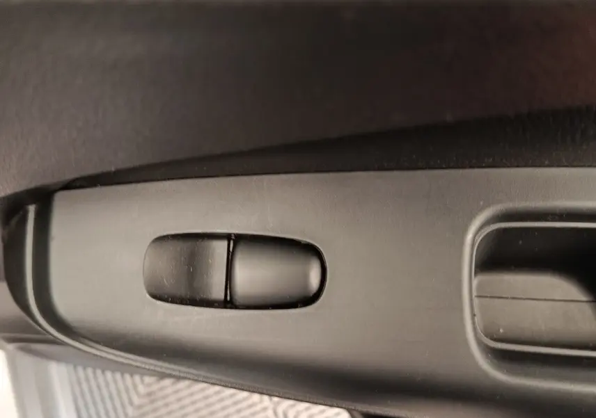 Gros plan sur la commande de réglage électrique du siège côté conducteur du Nissan Juke gris clair 2025.