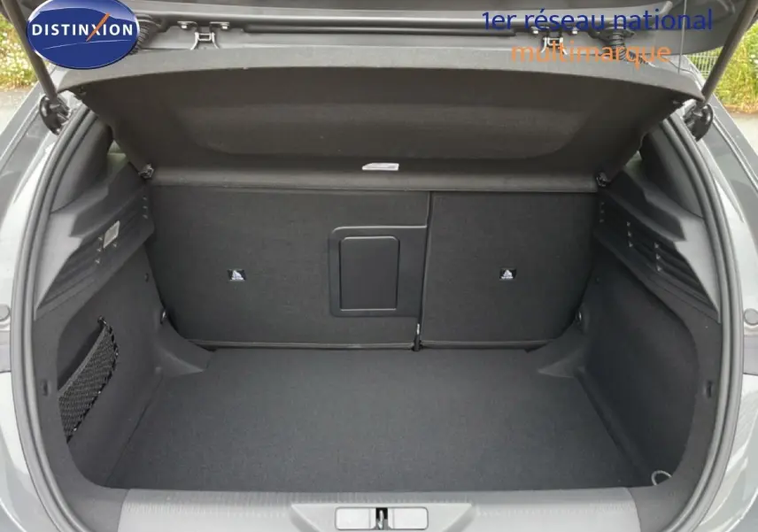 Coffre ouvert vu de l'arrière d'une Peugeot 308 gris selenium metal, espace de chargement propre et spacieux.