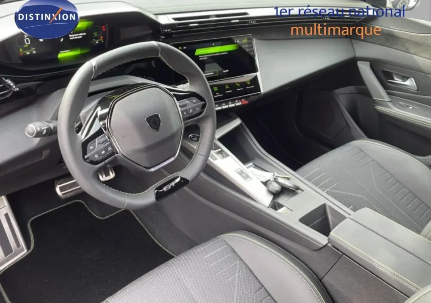 Vue intérieure de la Peugeot 308 1.2 Hybrid 145ch GT, montrant le volant multifonction et la console centrale moderne.