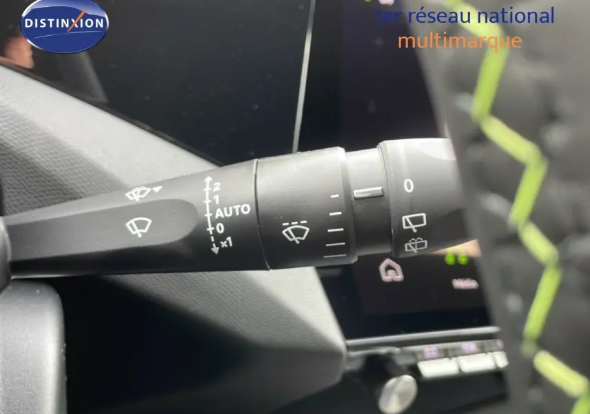 Gros plan sur la commande des essuie-glaces à gauche du volant d’une Peugeot 308 gris selenium metal, intérieur noir.