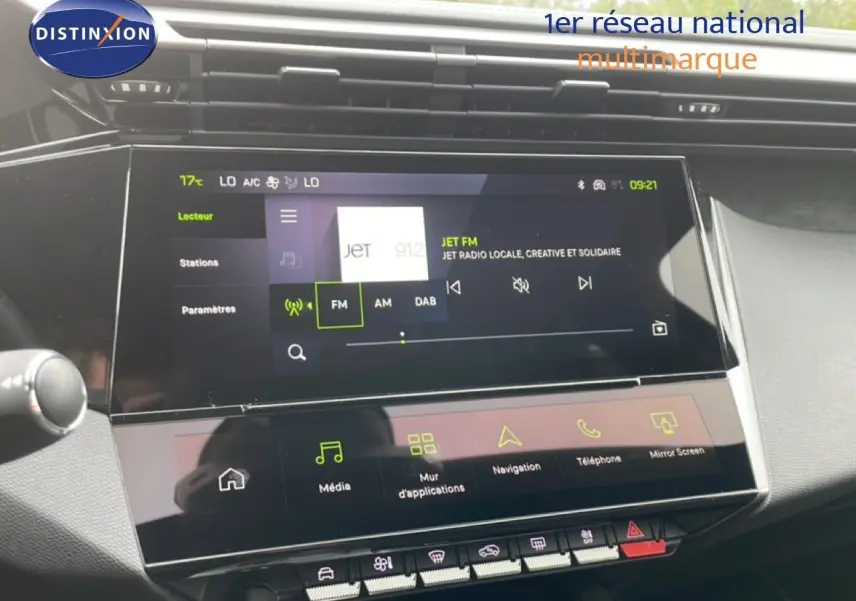Vue rapprochée de l’écran tactile central du tableau de bord de la Peugeot 308 gris selenium, affichant la radio FM.
