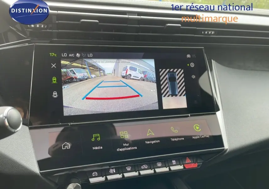 Vue intérieure du tableau de bord de la Peugeot 308 hybride 2026, écran tactile affichant la caméra de recul et les commandes multimédia.