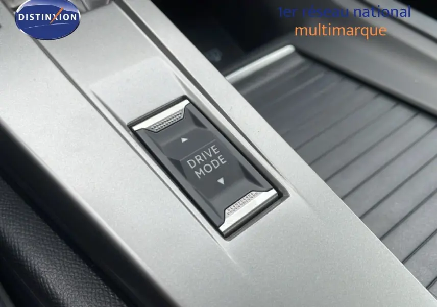 Gros plan sur le bouton Drive Mode au centre de la console intérieure d’une Peugeot 308 gris selenium metal.