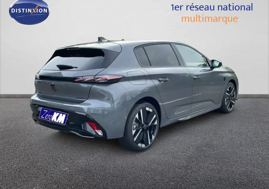 Peugeot 308 gris selenium métal vue 3/4 arrière droit, avec jantes alliage noires et feux arrière LED fins.