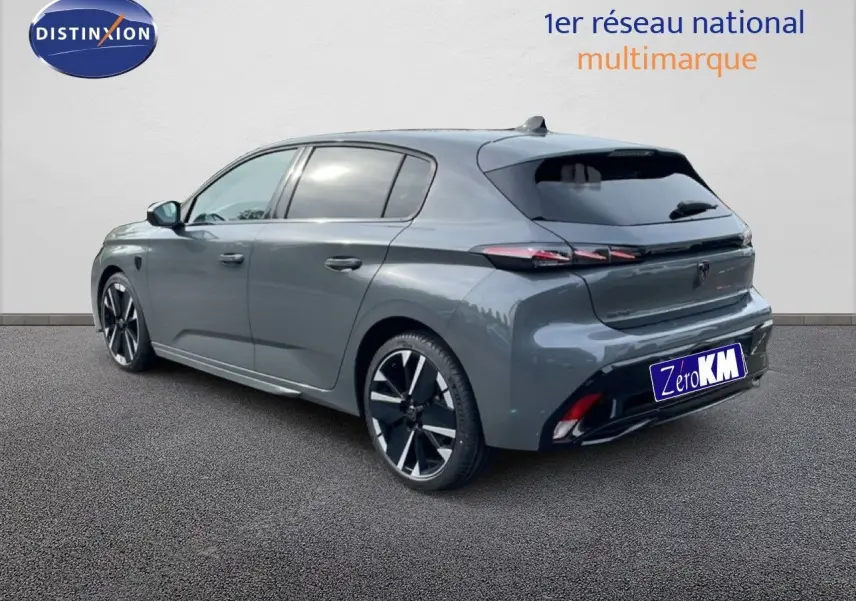 Peugeot 308 gris selenium métal vue 3/4 arrière côté gauche, avec jantes alliage et feux arrière LED distinctifs.