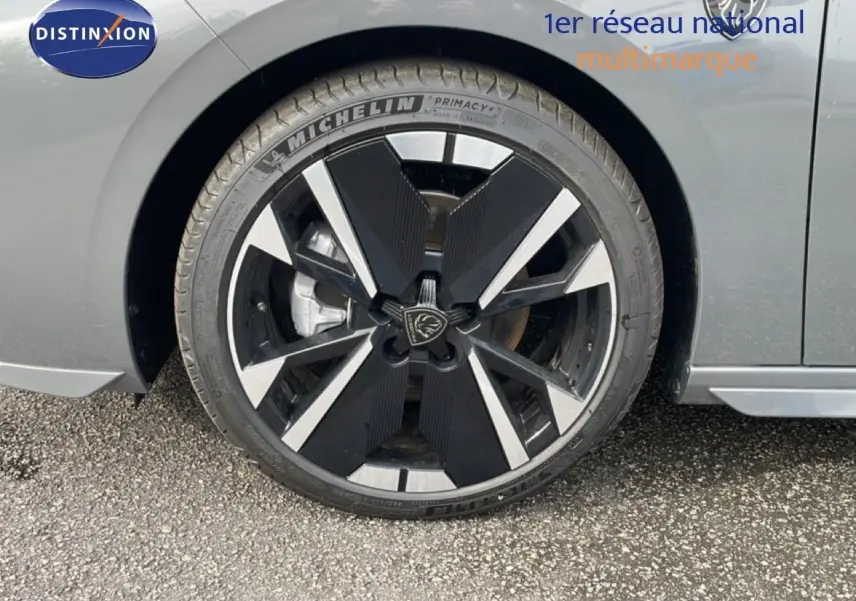 Gros plan sur la roue avant droite d’une Peugeot 308 gris selenium metal avec jante noire et argentée au design moderne.