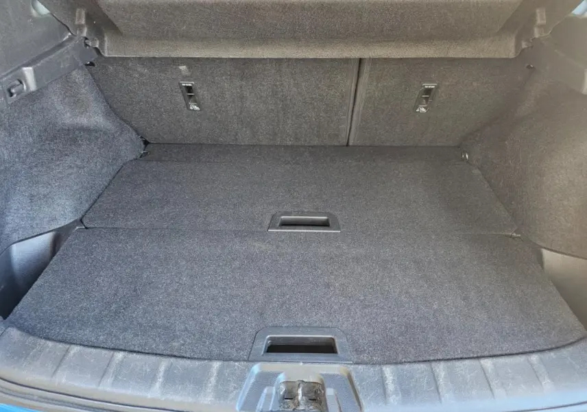 Coffre ouvert du Nissan Qashqai bleu 2019, vue intérieure montrant le plancher plat et les fixations arrière.