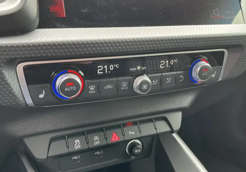 Gros plan sur la console centrale de l'Audi A1 Sportback 25 TFSI 2022 montrant la climatisation automatique bi-zone et les commandes.