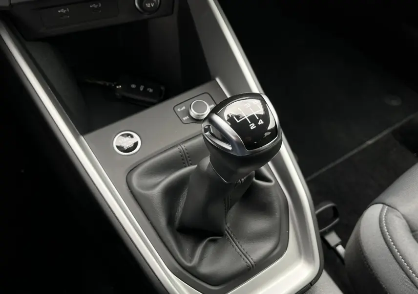 Le levier de vitesses manuel noir de l'Audi A1 Sportback 25 TFSI Advanced vu de dessus avec la clé mains libres à proximité.