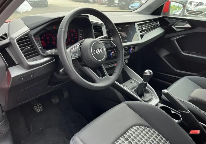 Intérieur de l'Audi A1 Sportback 2022 vu côté conducteur, volant cuir multifonctions et levier de vitesses manuel.
