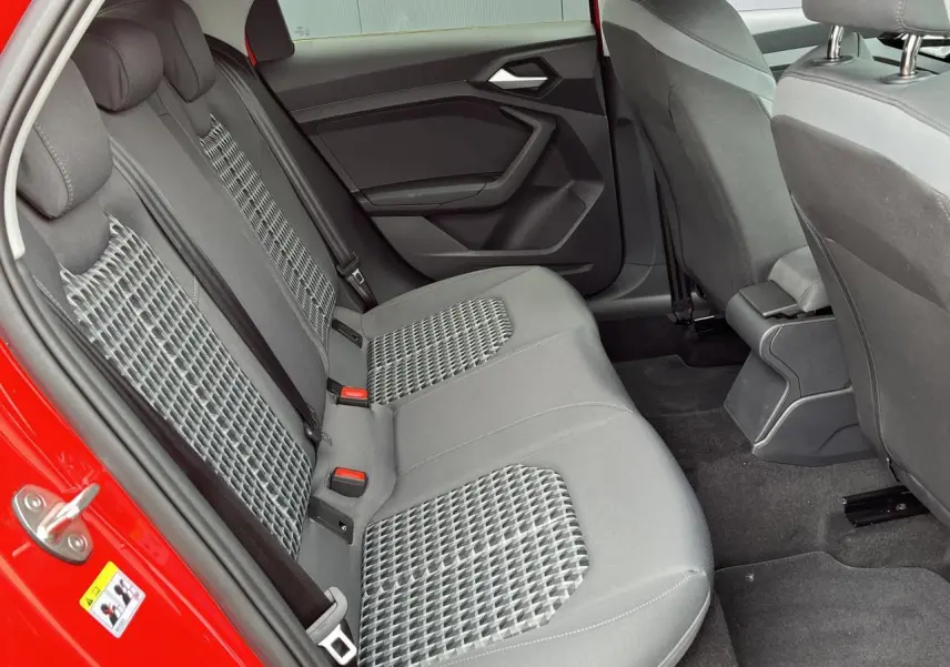 Vue intérieure côté gauche des sièges arrière gris à motifs géométriques de l'Audi A1 Sportback rouge Misano 2022.