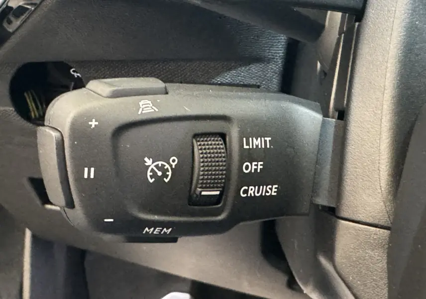 Gros plan sur la commande de régulateur de vitesse noir mat à gauche du volant du DS7 Crossback bleu E-TENSE 2020