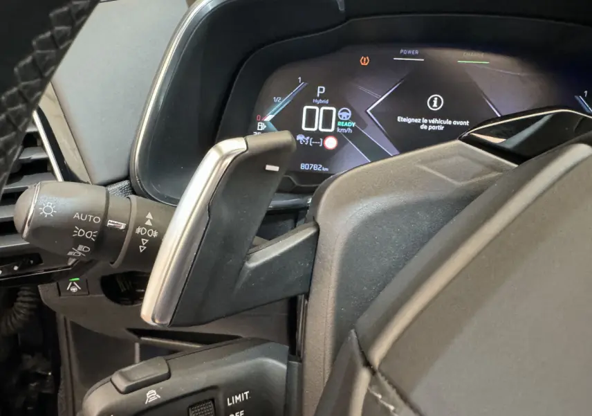 Gros plan sur le levier de vitesses et le tableau de bord numérique du DS7 Crossback E-TENSE bleu, affichage hybride et 80 782 km.