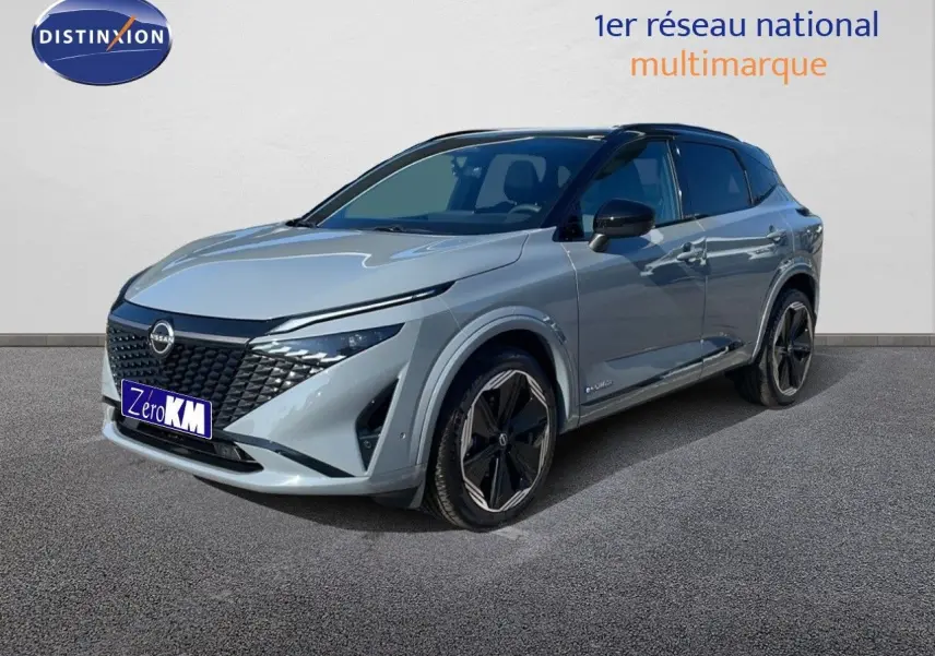 Nissan Qashqai 2025 gris céramique avec toit noir, vue 3/4 avant mettant en valeur sa calandre distinctive et ses jantes noires.