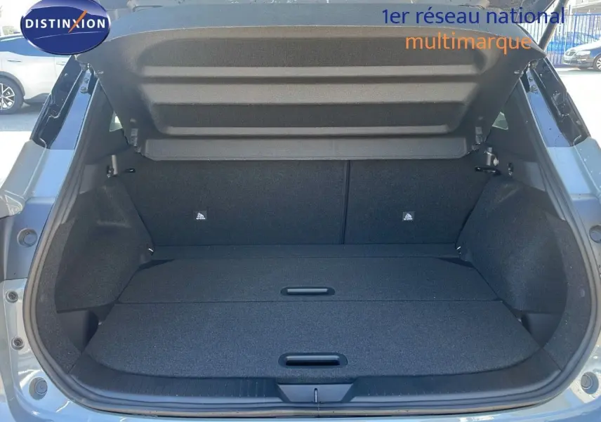 Coffre ouvert du Nissan Qashqai 2025 gris céramique avec toit noir, vue arrière montrant l'espace de chargement vide.