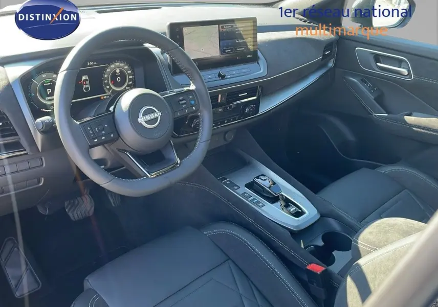 Intérieur du Nissan Qashqai 2025 vu côté conducteur, tableau de bord moderne avec écran tactile et sellerie noire cuir et alcantara.