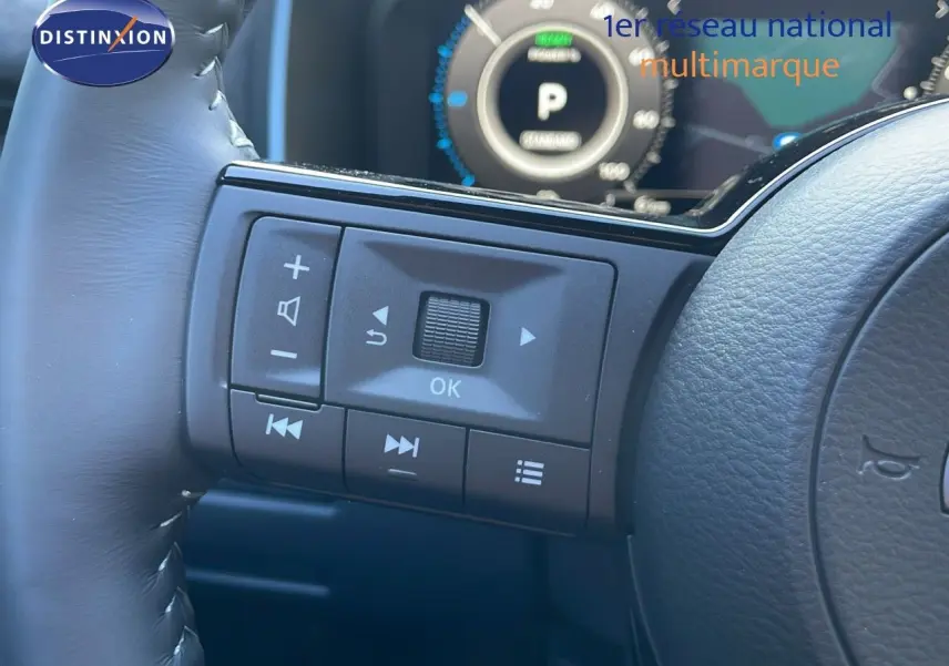 Vue rapprochée des commandes au volant à gauche du Nissan Qashqai 2025 gris céramique avec toit noir.