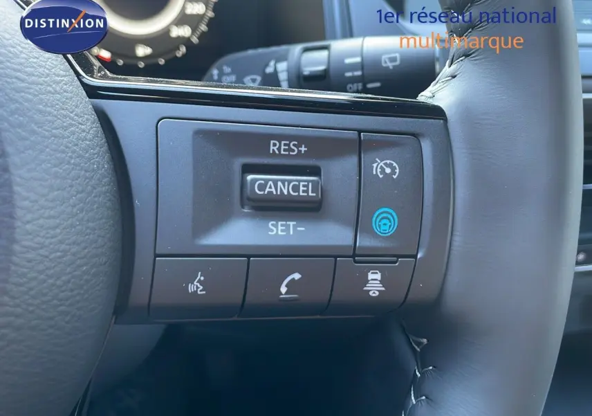 Gros plan sur les commandes de régulateur de vitesse au volant cuir noir du Nissan Qashqai gris céramique 2025.