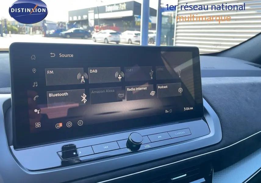 Écran tactile central du Nissan Qashqai 2025, affichant les options multimédia avec tableau de bord noir et gris.