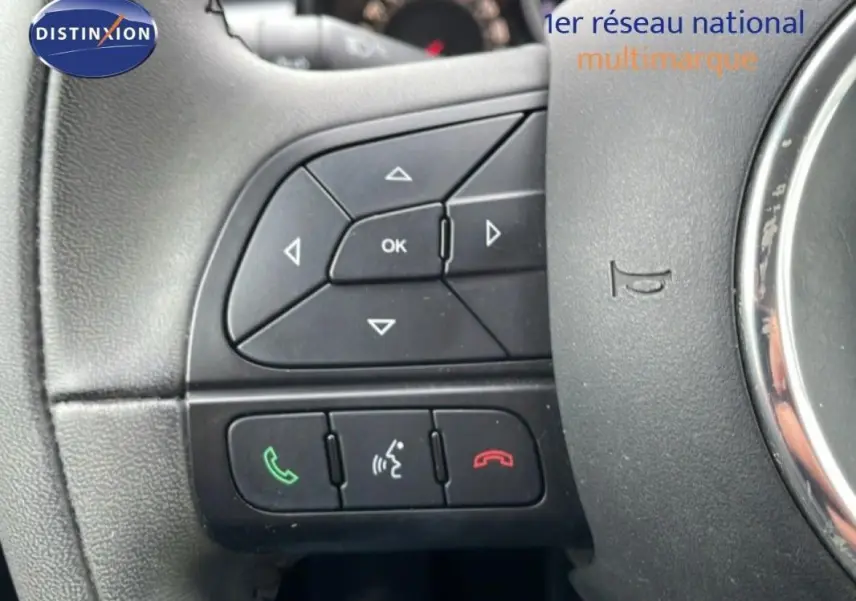 Gros plan sur les commandes au volant à gauche du Fiat 500X gris foncé MY18 avec boutons de gestion d'appels et menu.