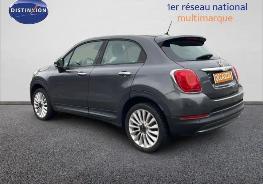 Fiat 500X gris foncé vue 3/4 arrière droit, jantes alliage 18 pouces et feux arrière rouges visibles.