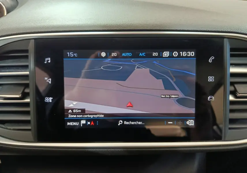 Écran tactile central du tableau de bord de la Peugeot 308 blanc, affichant la navigation GPS en mode carte.