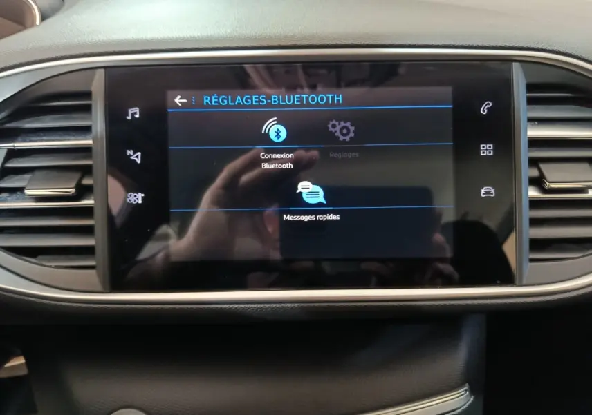 Écran tactile central affichant les réglages Bluetooth du Peugeot 308 blanc, vue frontale intérieure du tableau de bord.