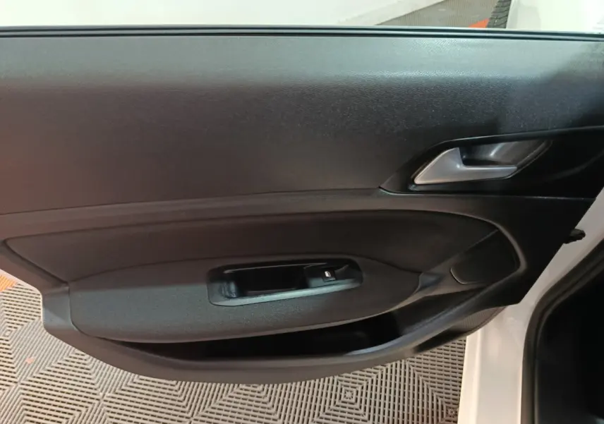 Vue rapprochée de la porte avant gauche noire de la Peugeot 308 blanche, mettant en valeur la poignée et le bouton de verrouillage.