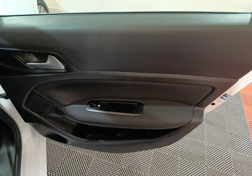 Vue intérieure sur la porte côté gauche d'une Peugeot 308 blanche, avec garniture noire et poignée intégrée.