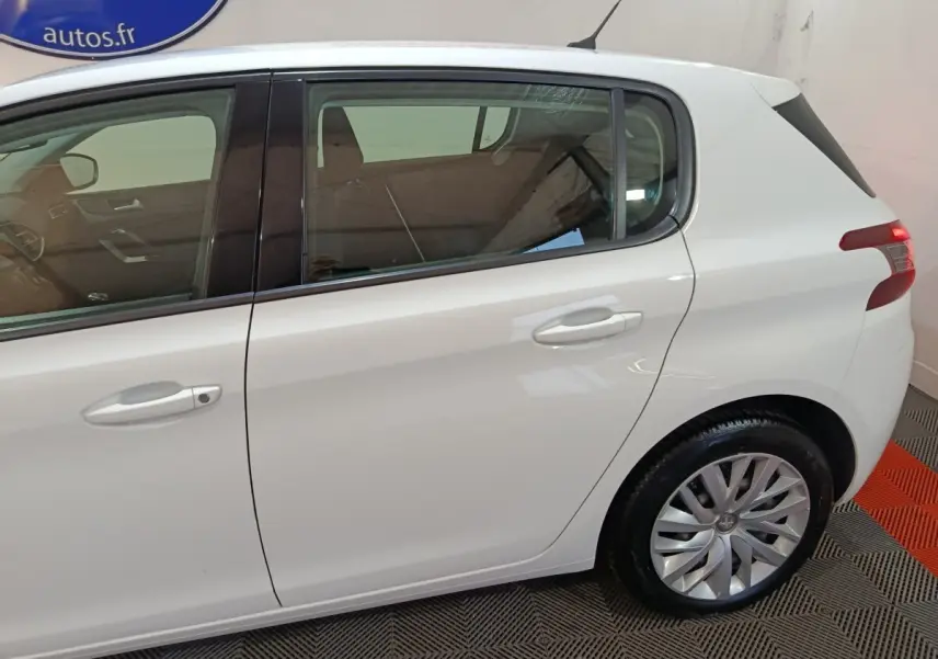 Vue latérale côté droit d'une Peugeot 308 blanche, mettant en valeur les portes arrière et la roue arrière.