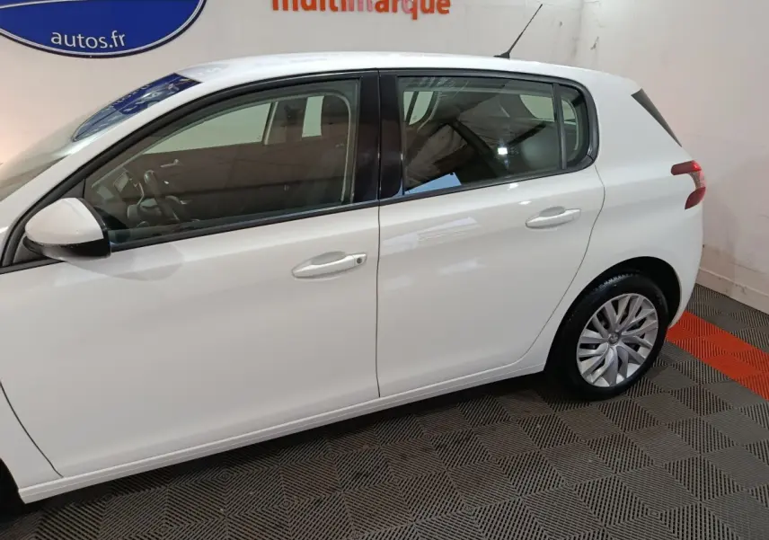 Profil côté gauche d'une Peugeot 308 blanche de 2021, mettant en valeur ses lignes épurées et ses jantes alliage.