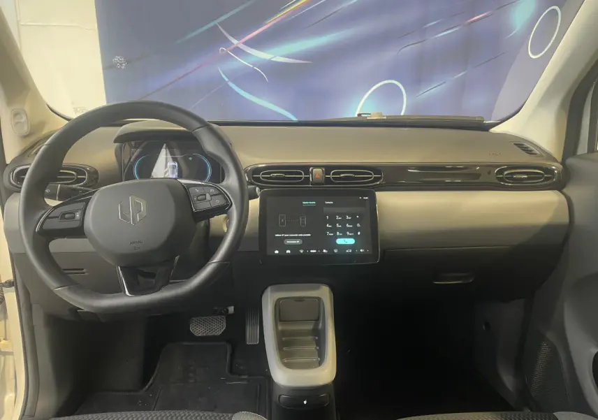 Vue intérieure frontale du tableau de bord du Leapmotor T03 Luxury blanc avec volant cuir multifonctions et écran tactile central.