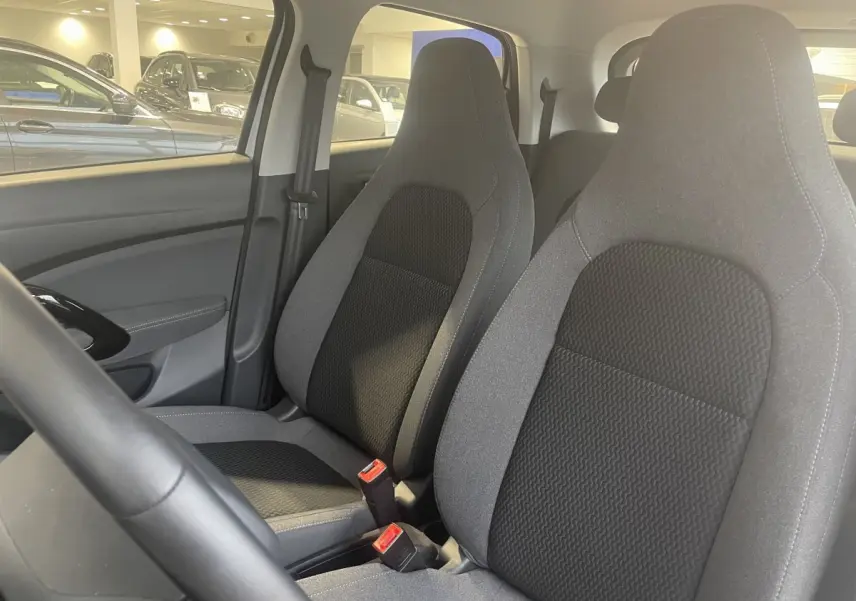 Vue intérieure sur les sièges avant gris et noirs du LEAPMOTOR T03 Luxury, avec volant partiellement visible côté gauche.