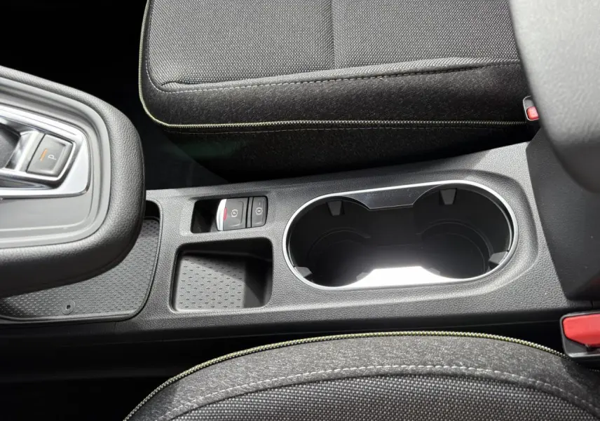 Gros plan sur la console centrale noire avec porte-gobelets et bouton de frein à main électrique du Renault Symbioz 2025.