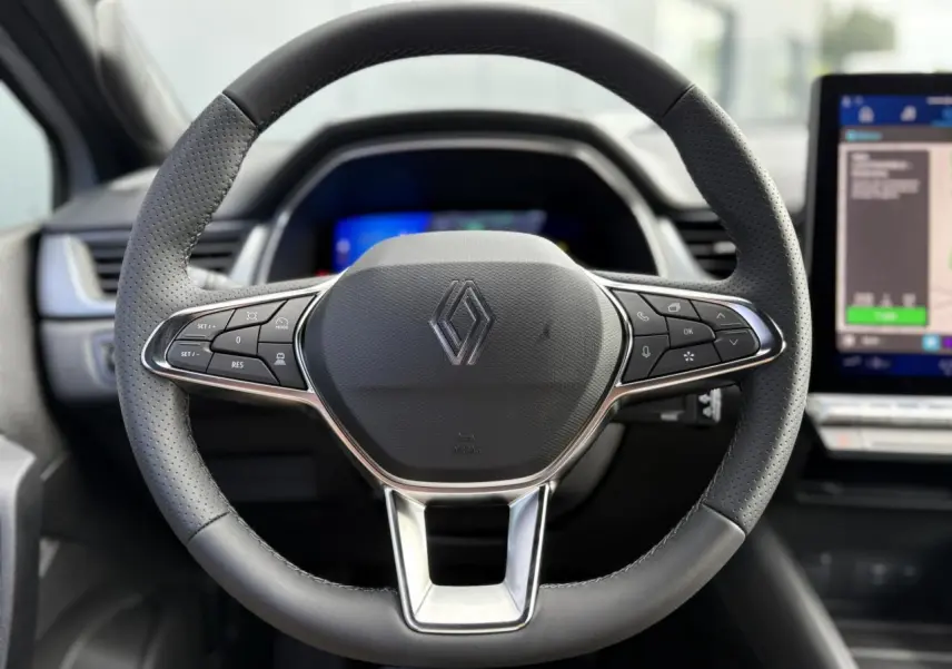 Volant multifonction en cuir Renault vu de face avec tableau de bord numérique et écran tactile à droite.