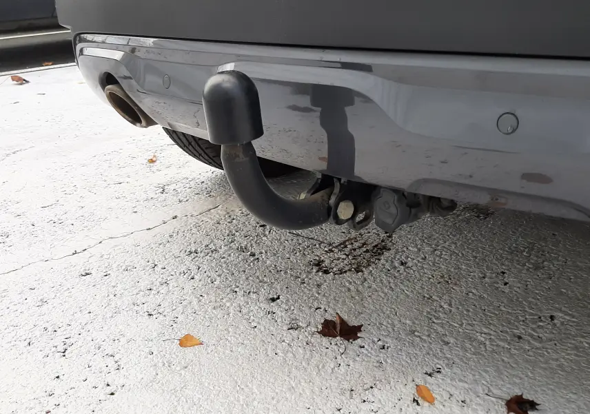 Gros plan sur l'attelage de remorque noir fixé à l'arrière du Renault Captur blanc au toit noir.