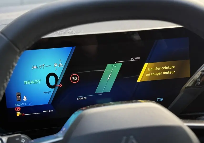 Tableau de bord numérique du Renault Espace VI hybride, affichage mode Eco et alertes de sécurité visibles.