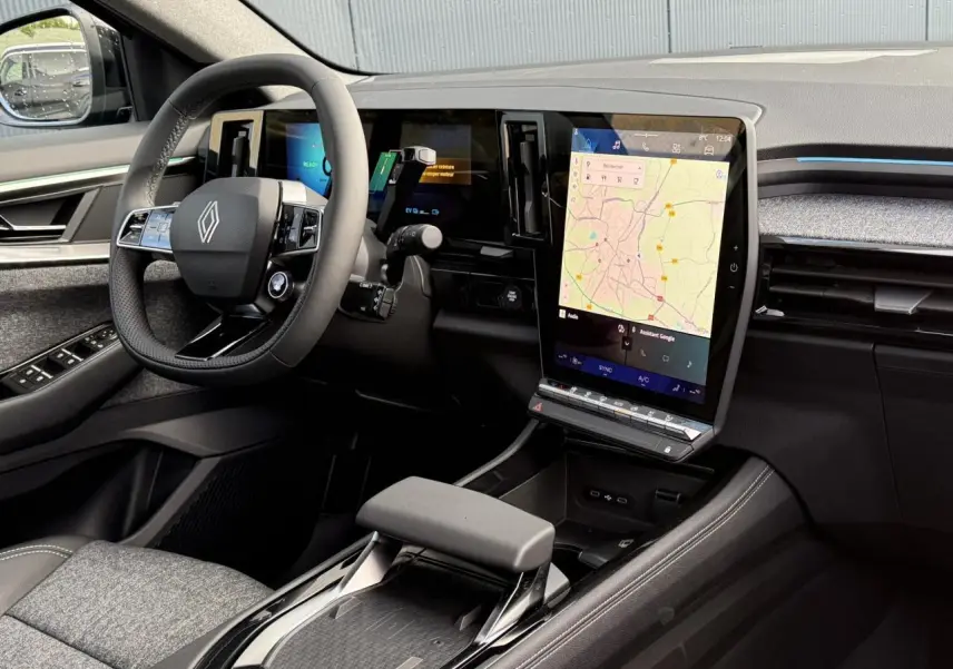 Vue intérieure côté conducteur du Renault Espace VI hybride, avec grand écran tactile vertical et volant cuir noir.
