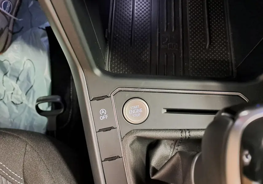 Gros plan sur le bouton Start Engine Stop et la console centrale du Volkswagen Taigo gris cendré, version R-Line 2025.