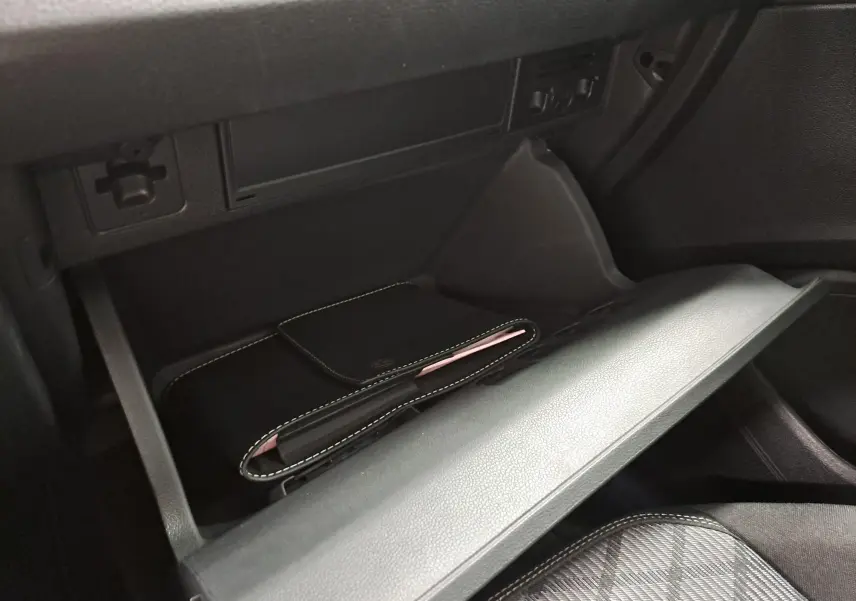 Gant de boîte à gants ouvert avec pochette noire à surpiqûres blanches, intérieur du Volkswagen Taigo 2025.